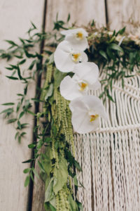 white orchids on macrame backdrop wedding