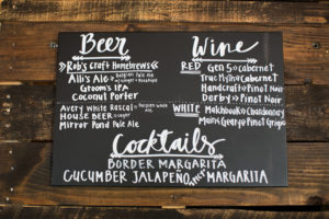 chalkboard drink menu on wooden wall