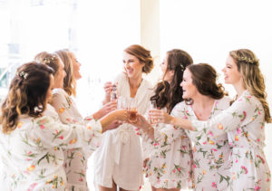 bride and bridesmaids cheers in rompers