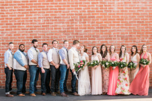 bridal party in front of brick wall