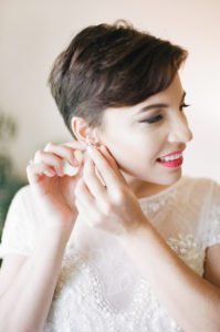 bride short share putting earrings on