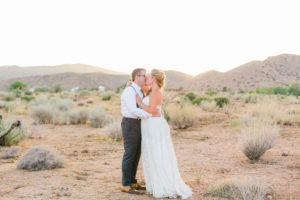 bride and groom kiss in the desert in joshua tree