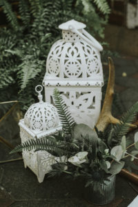 white lanterns and antlers with fern by ceremony arch