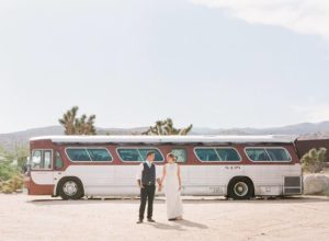 bride and groom at rimrock ranch in front of vintage bus