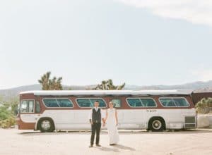 bride and groom in front of vintage bus at rimrock ranch