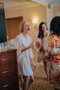 bride laughing and bridesmaids in cute floral robes