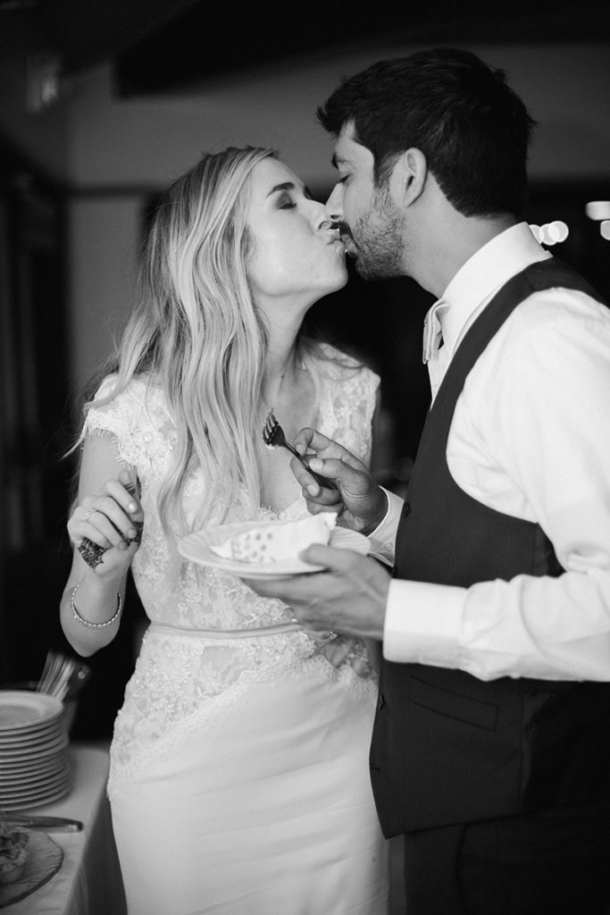 bride and groom kiss after cake cutting