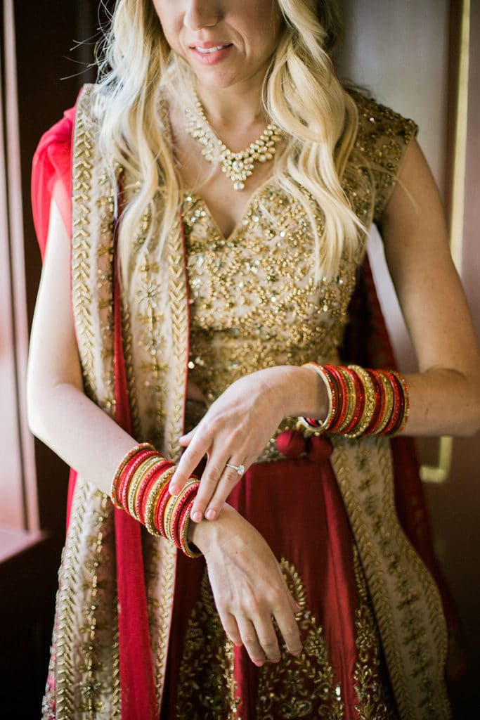 bride in red and gold lehenga with red and gold bracelets for indian fusion wedding