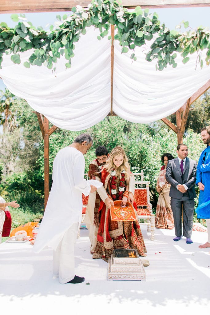 indian wedding under simple mandap with green garland in garden