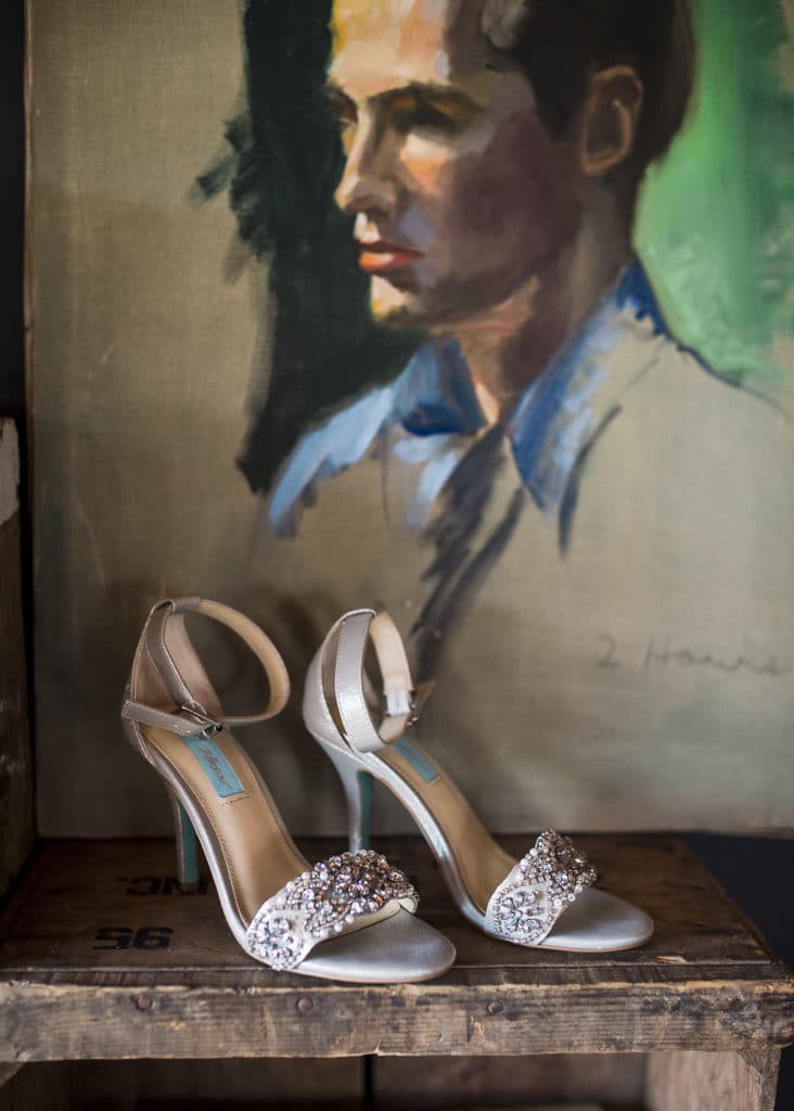 bridal shoes in front of cool art piece