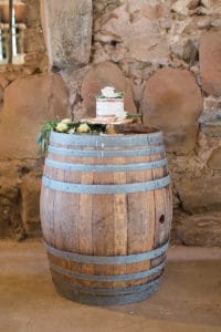 Beautiful simple naked cake on wine barrel for rustic barn wedding