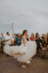 Bride twirling in flowy wedding dress in the desert