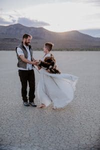 A bride and groom pose in the Black Rock Desert for their Burning Man wedding.