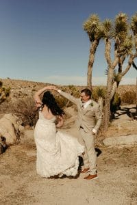 Bride and groom dance in desert at Joshua Tree National Park