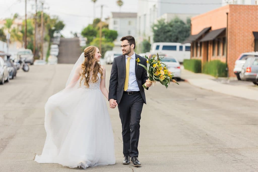 Bride and groom holding hands at spring wedding